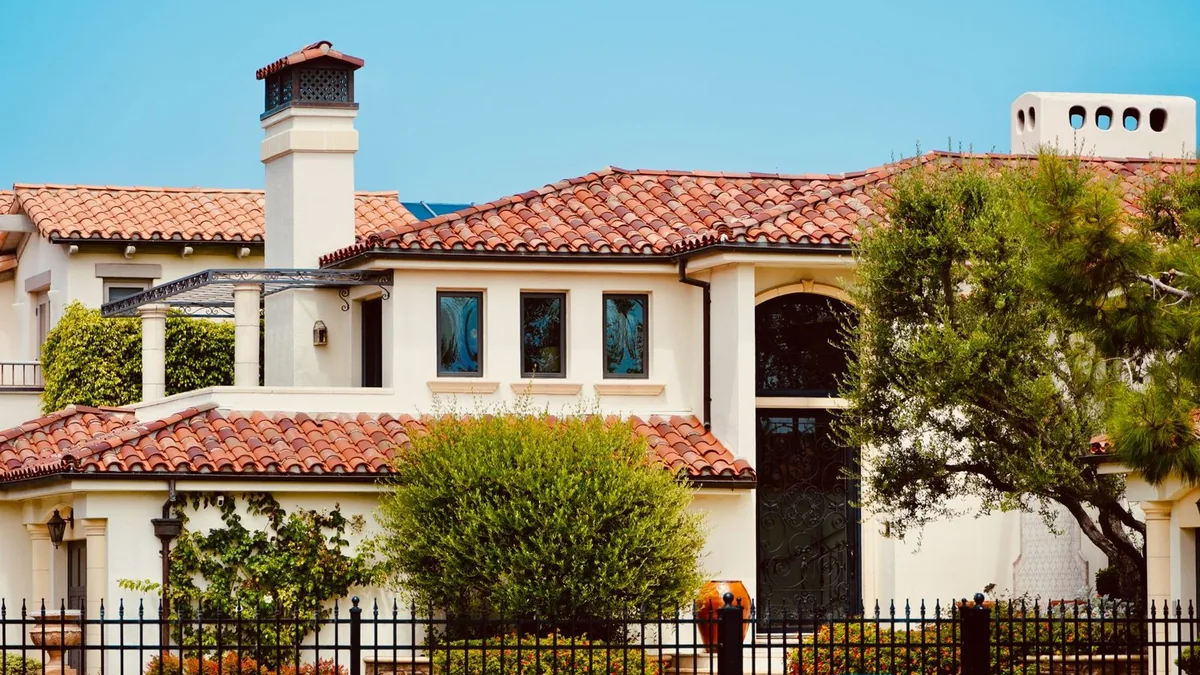 A single family stucco home with a tile roof and palm trees on a sunny Las Vegas street, the kind of Clark County property a divorcing couple has to divide